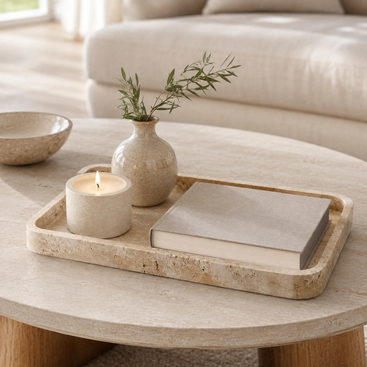 Bandeja Celine sobre mesa de centro com vela, livro e vaso decorativo