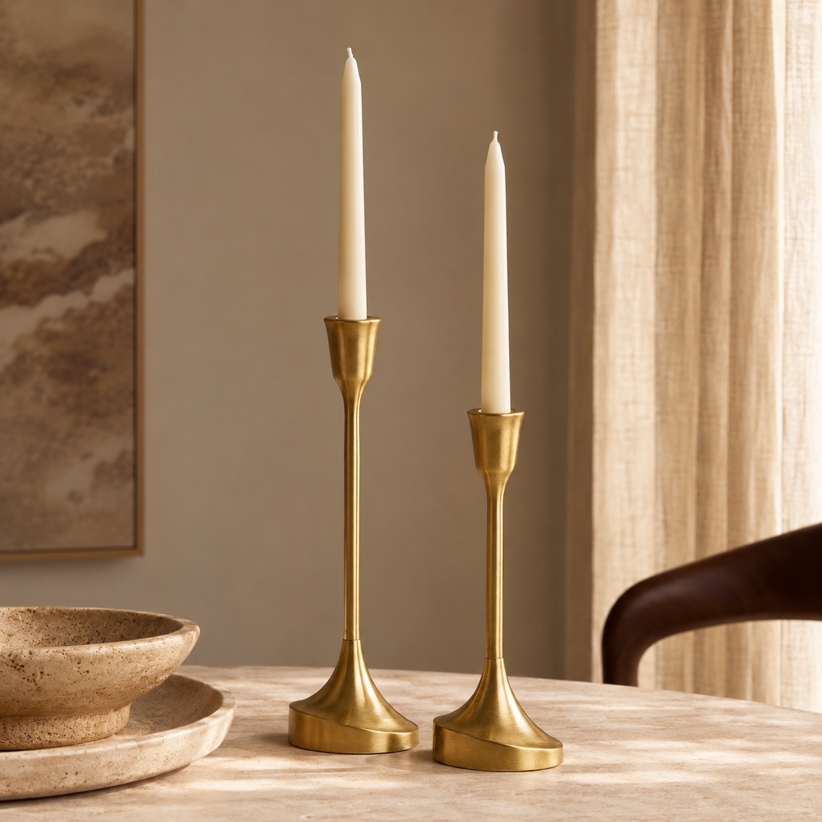 Castiçais Montreux em latão com velas sobre mesa em ambiente sofisticado