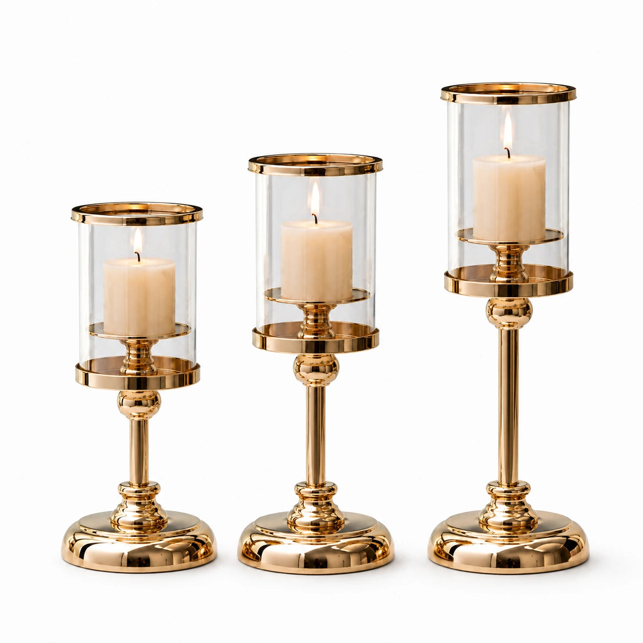 Trio de castiçais Aurélie dourados com velas acesas em composição decorativa