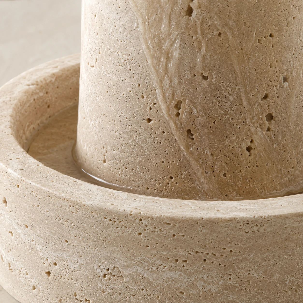 Detalhe da textura porosa e das nuances do travertino natural da Fonte Decorativa Amana