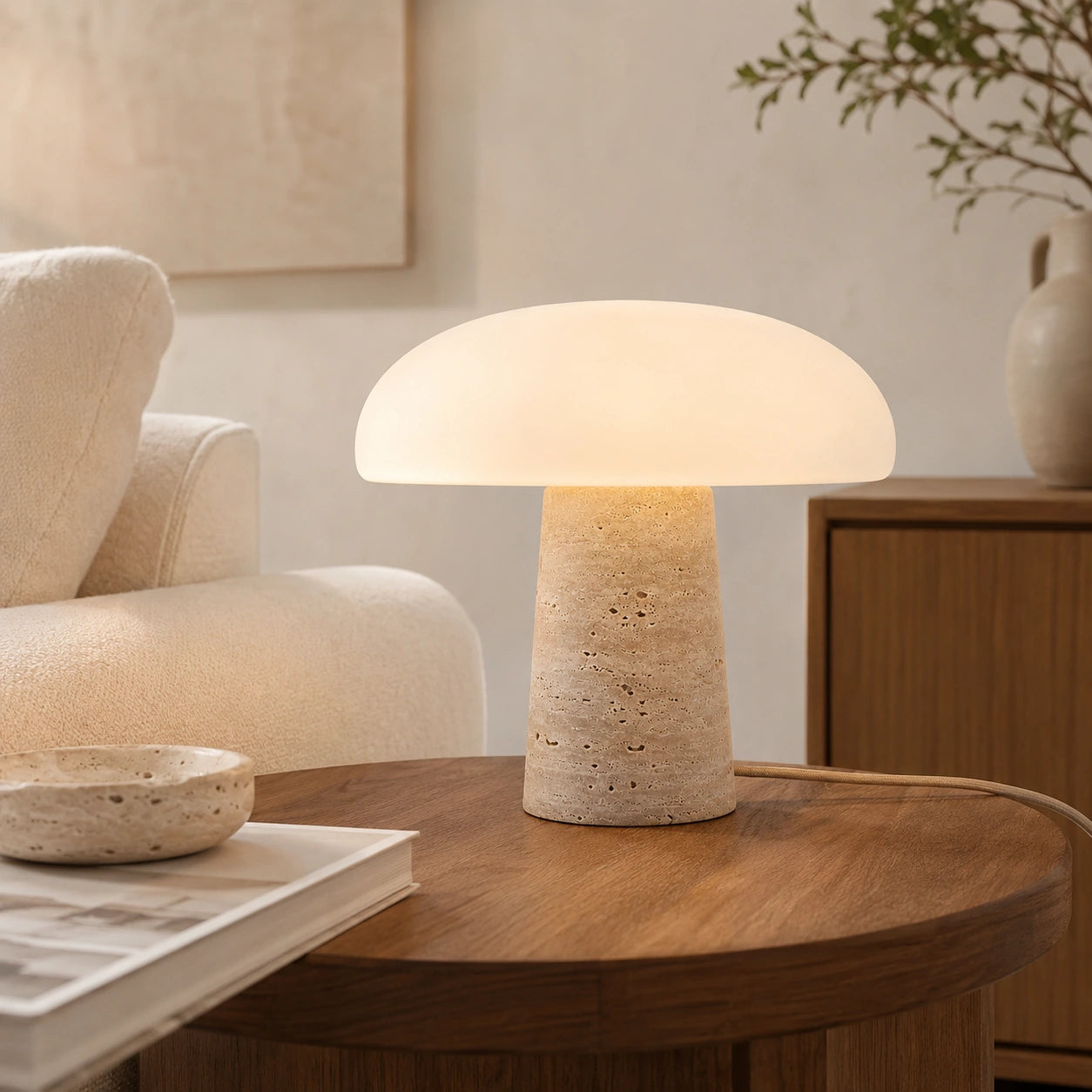 Luminária Cala acesa sobre mesa lateral em sala de estar com sofá claro e madeira natural