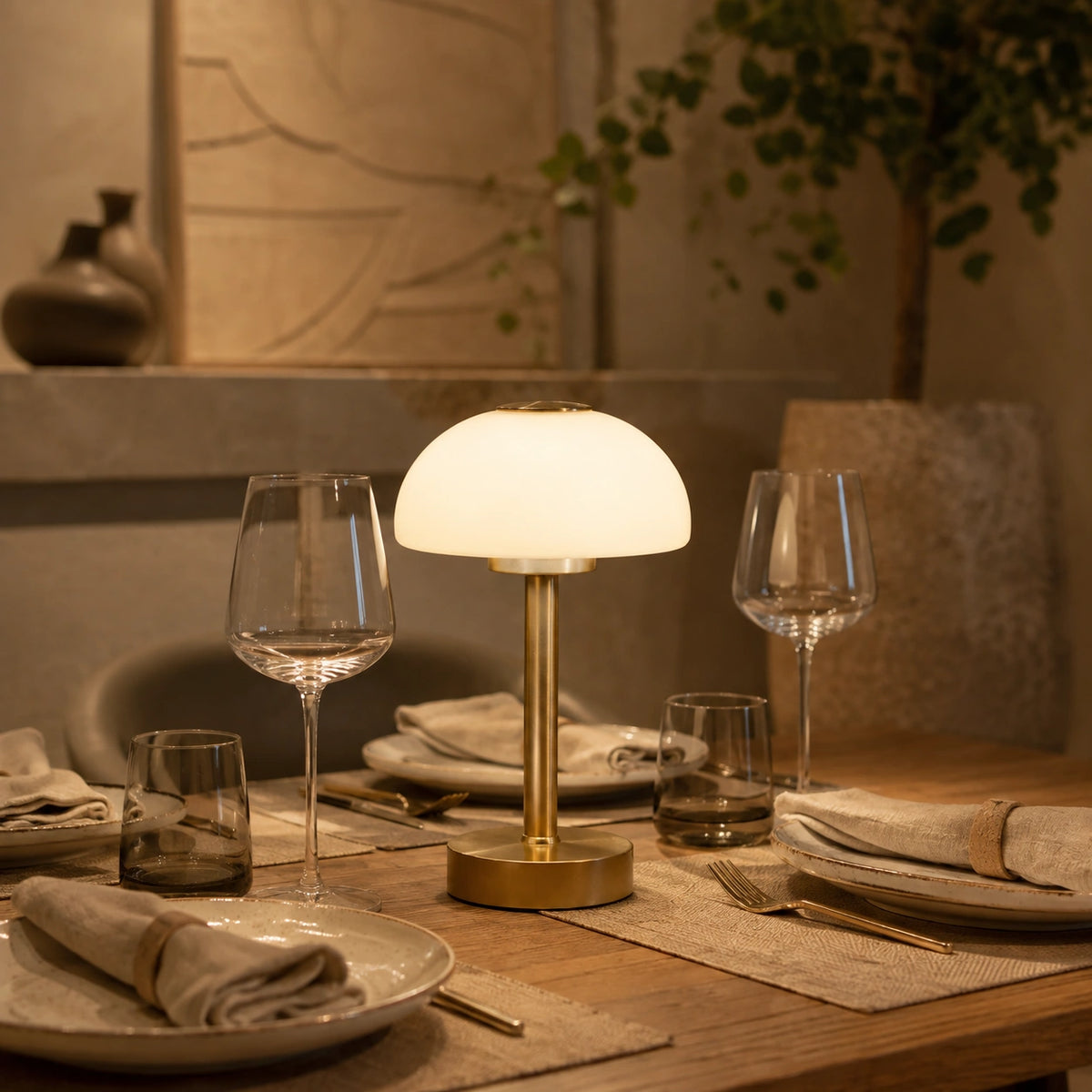 Luminária Portátil Alina acesa sobre mesa de jantar premium com luz quente e composição sofisticada