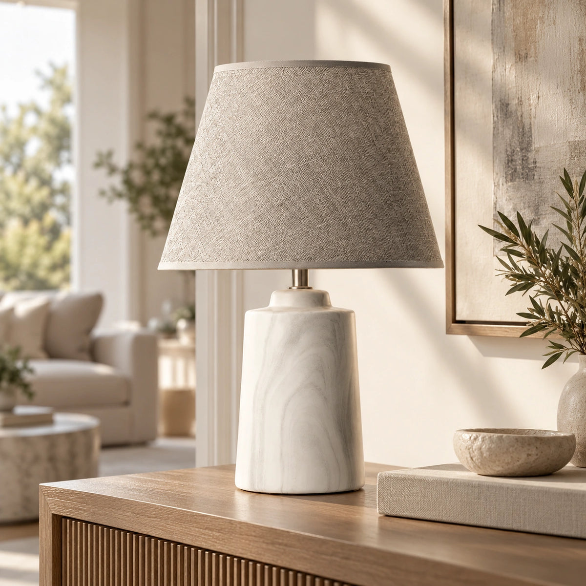 Luminária de mesa com base em cerâmica mineral sobre aparador em ambiente contemporâneo