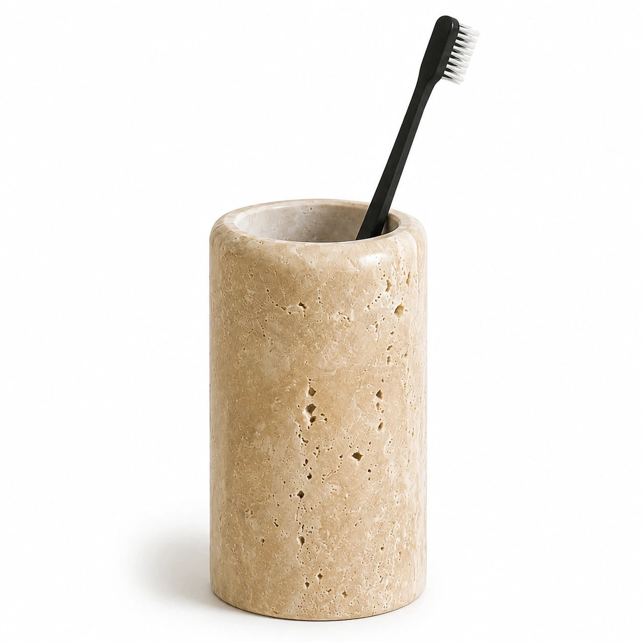 Porta-escovas Valence em travertino natural com escova de dentes sobre fundo branco