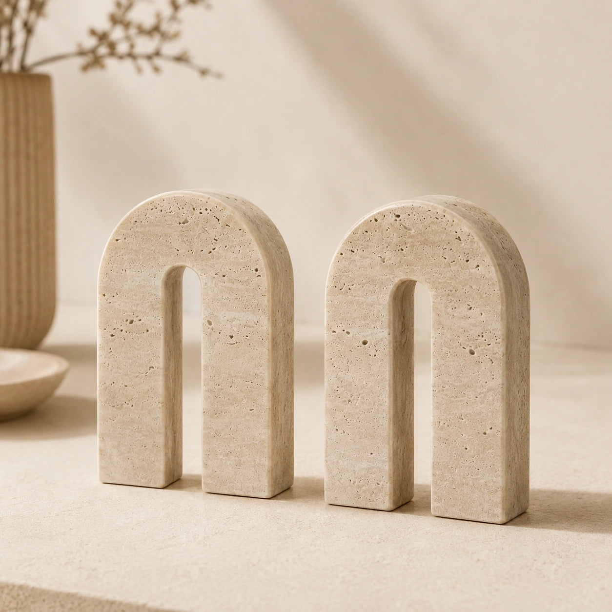 Conjunto Aurèle em travertino natural em composição minimalista sobre aparador