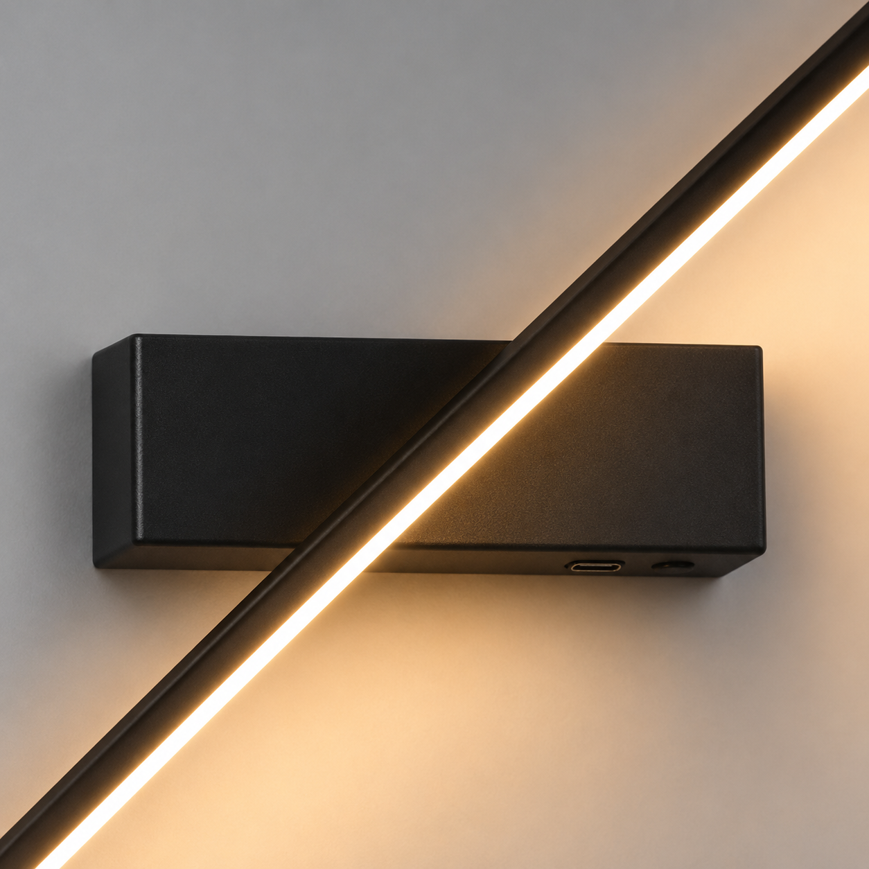 Detalhe da estrutura preta e da faixa de iluminação quente da Arandela Lume linear LED.
