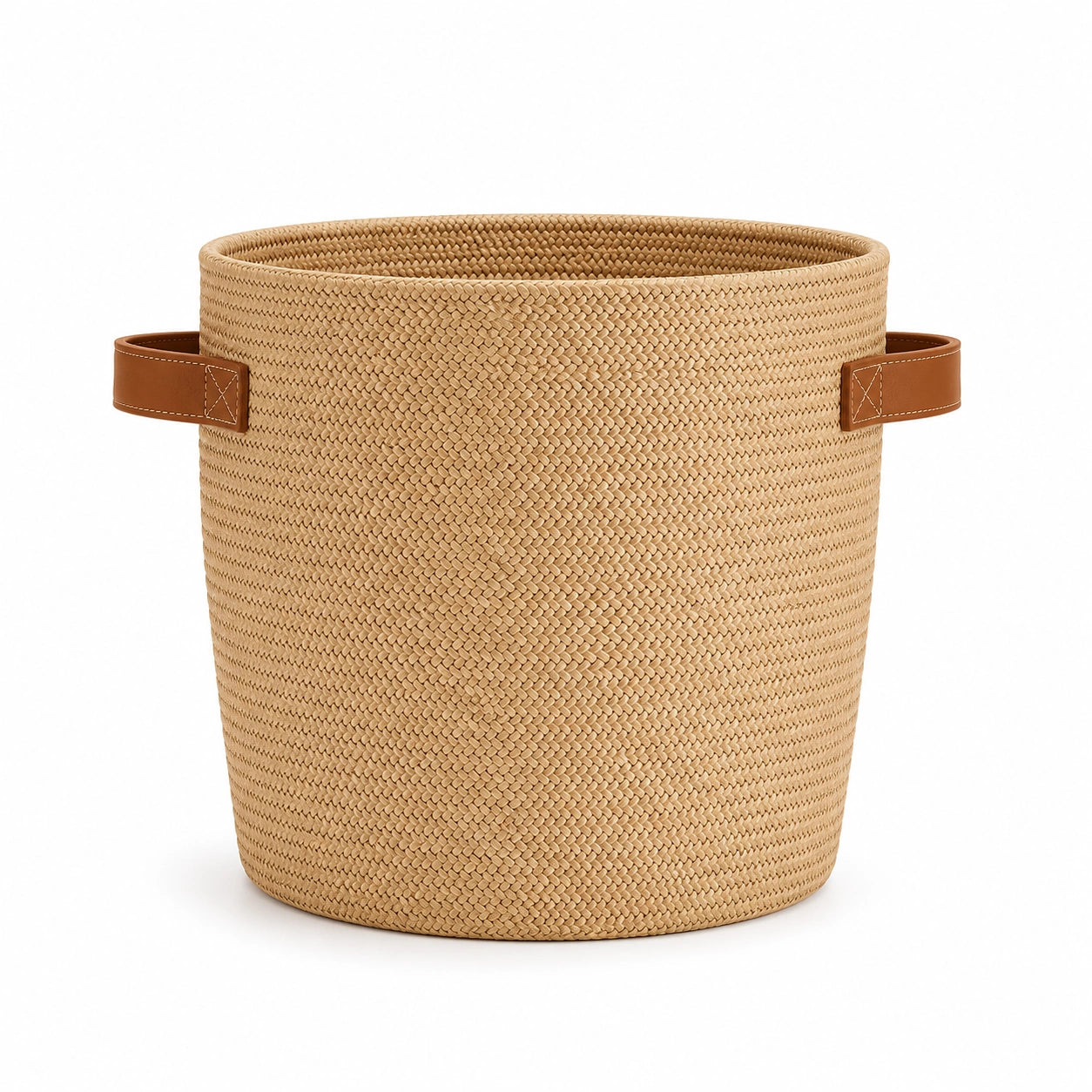 Cachepot Iara em fibra natural trançada com alças em couro caramelo sobre fundo branco