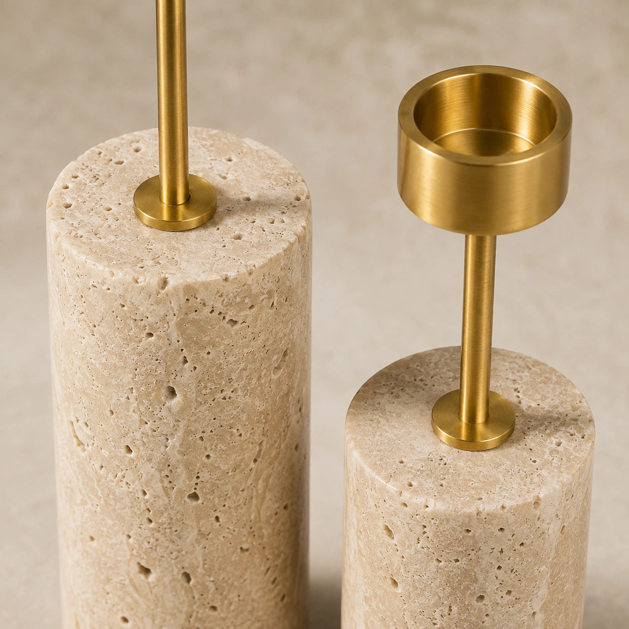 Detalhe do travertino natural, dos poros da pedra e do acabamento em metal dourado dos Castiçais Élodie