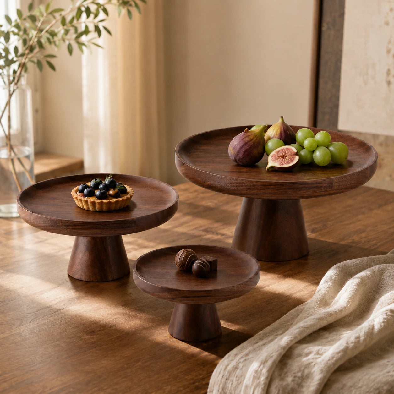Conjunto de bandejas pedestal em madeira com frutas, doces e composição elegante sobre mesa