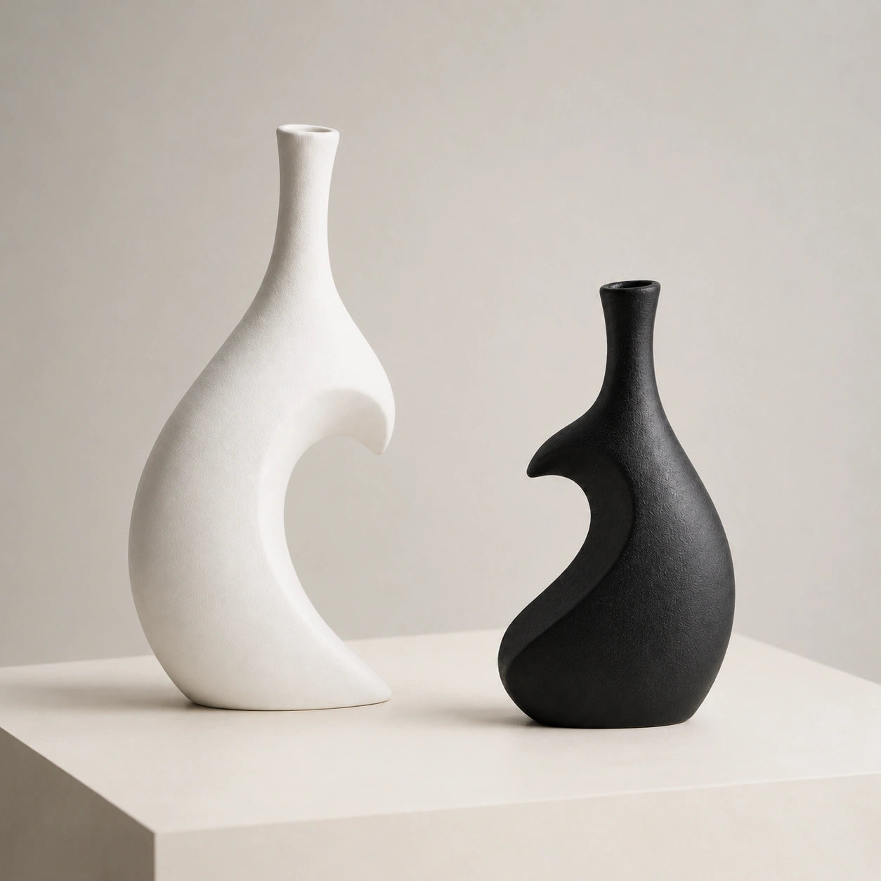 Vasos Enlace branco e preto separados para mostrar o design escultural