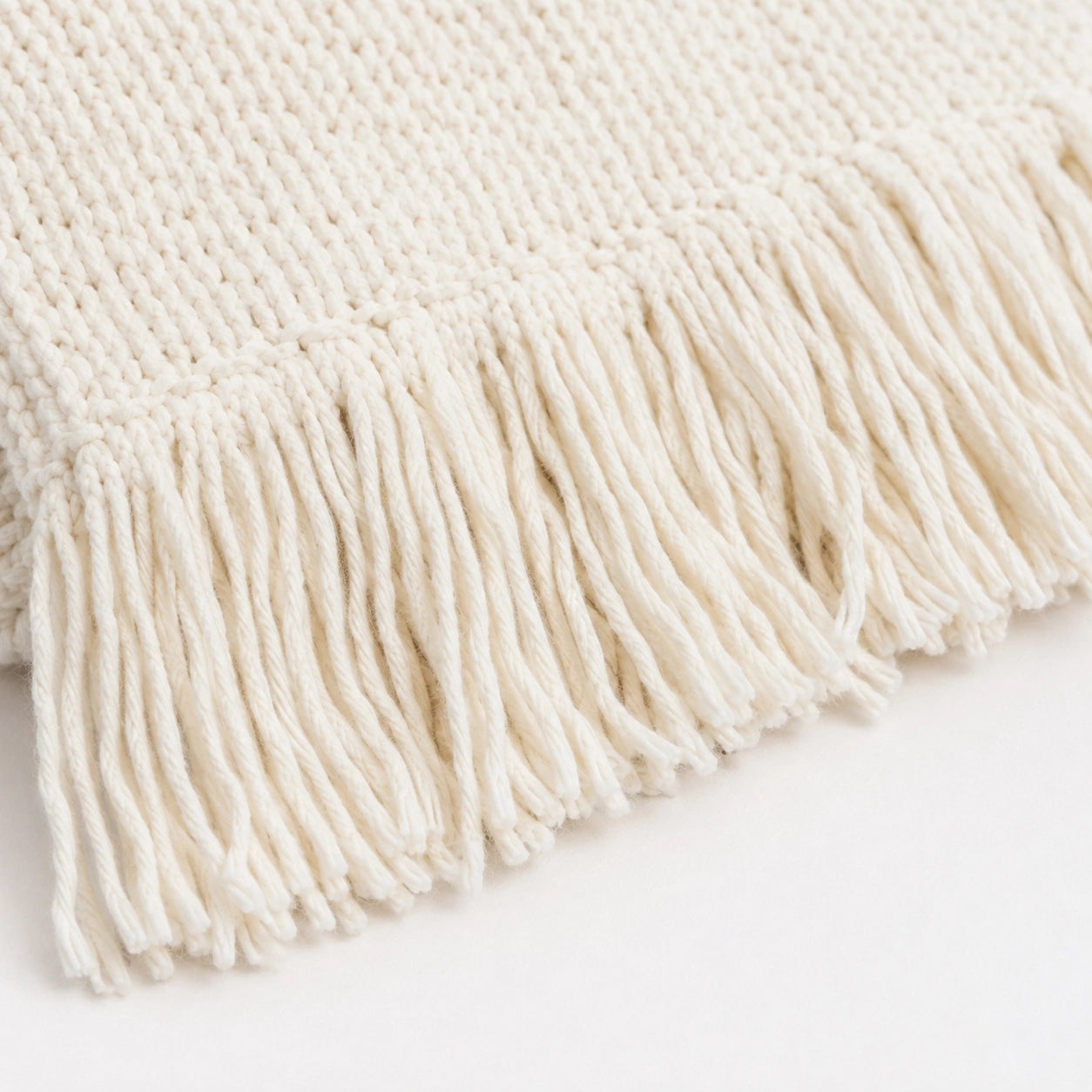 Detalhe das franjas e do acabamento off-white da Manta Ravie