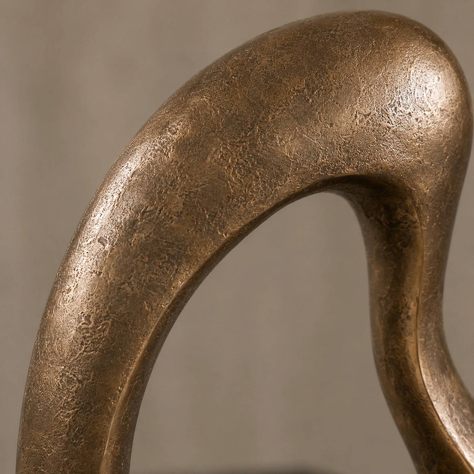 Detalhe da textura artesanal do alumínio fundido com acabamento bronze da Escultura Nara