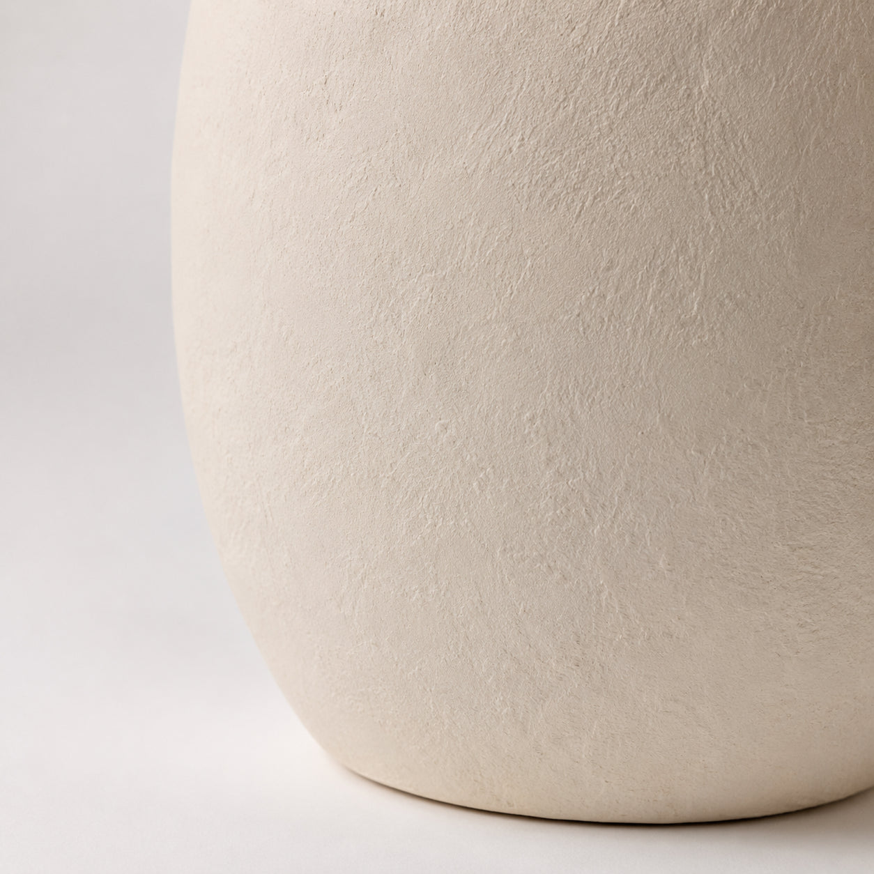 Detalhe da textura fosca da base em cerâmica off-white do Abajur Noa