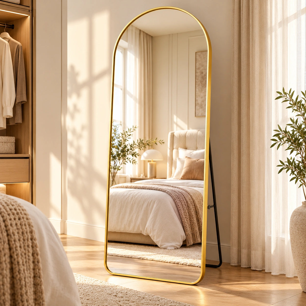 Espelho arqueado dourado de corpo inteiro em quarto elegante e acolhedor