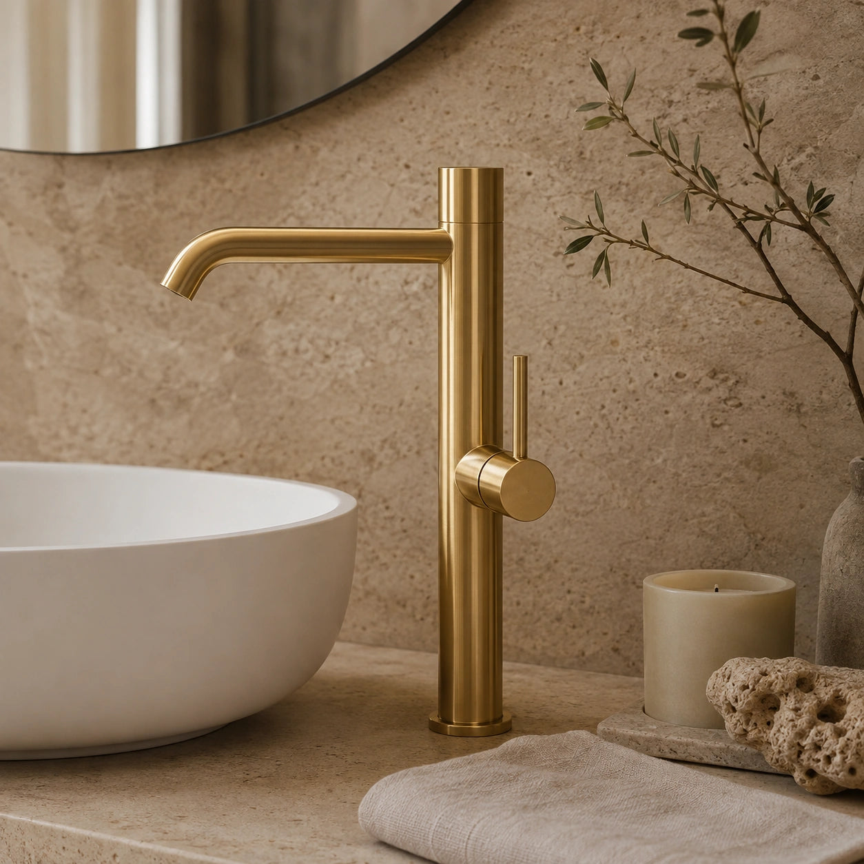 Torneira Lumière dourada em composição de lavabo premium com pedra natural e tons neutros